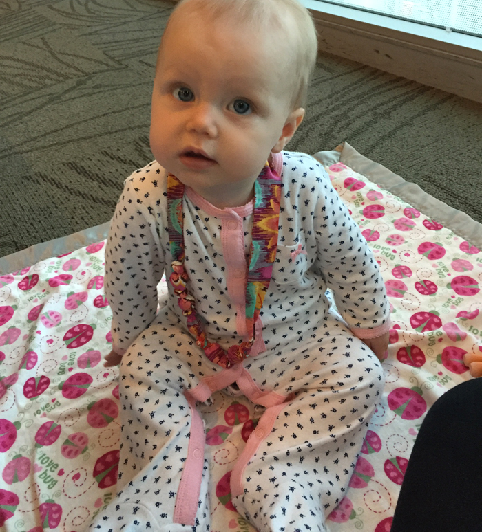 Amelia modeling a fabric covered bead necklace, perfect for teething!