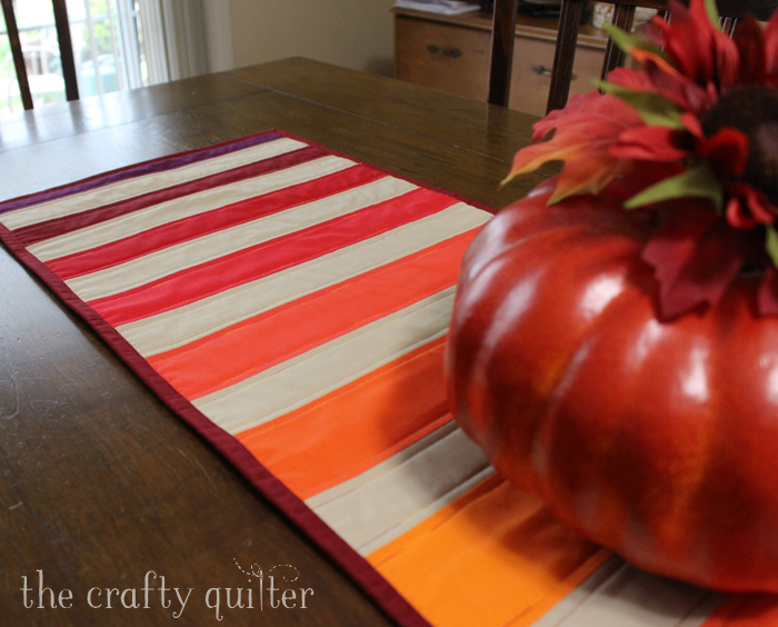 Pumpkin Spice Table Runner made by Julie Cefalu @ The Crafty Quilter. It's a simple design that packs a punch and it's perfect for the Fall holidays.
