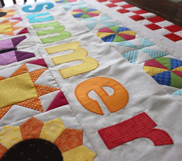 The Summer Fun Quilt Along @ The Crafty Quilter creates a bright and happy wall hanging that measures 30" x 32". Week 5 instructions include the SUMMER applique section and finishing instructions.