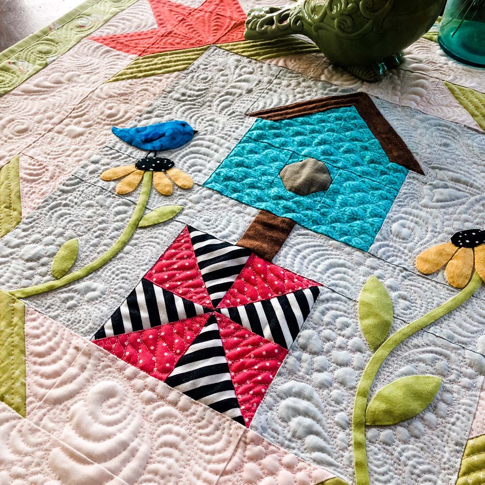 Spring is for The Birds is a 24" square wall hanging.  Free pattern at The Crafty Quilter.