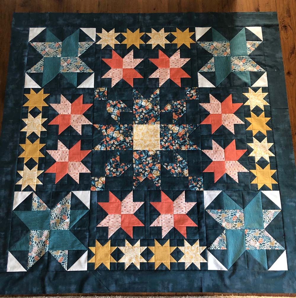 Simply Stars QAL final week includes the finishing instructions to make this beautiful 64" square quilt.  Hosted by Fat Quarter Shop.  This version was made by Julie Cefalu @ The Crafty Quilter using half yards of fabric from the Nutmeg collection by Basic Grey for Moda Fabrics.