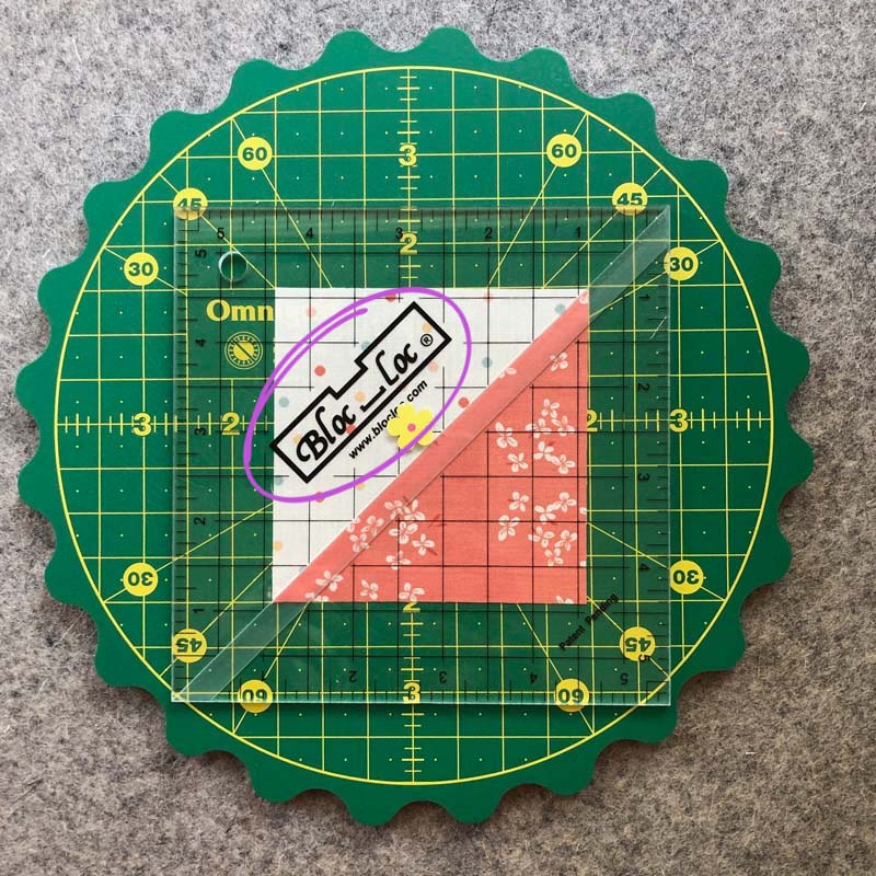 Favorite tools for trimming HST's includes this Bloc Loc ruler. Make sure the Bloc Loc label is placed on the lower seam allowance side of the HST unit.