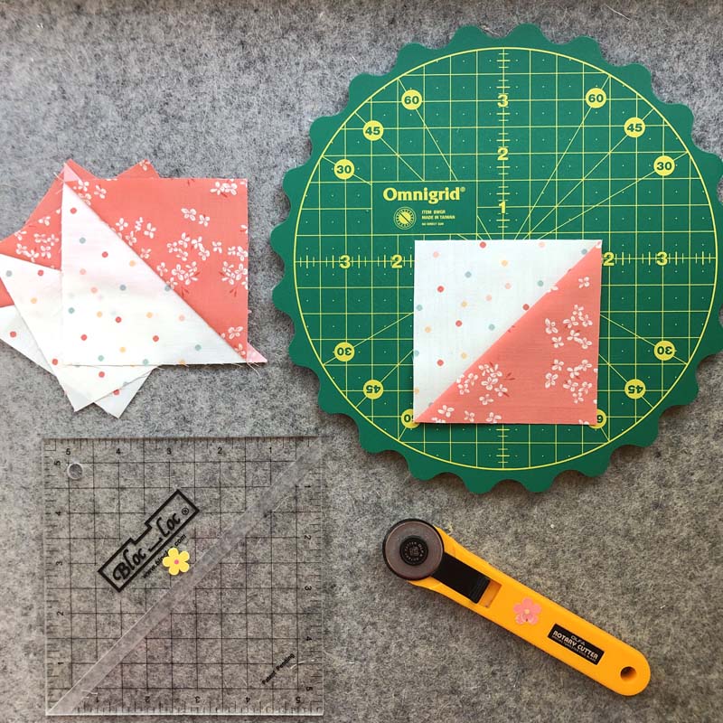 My favorite tools for trimming HST's include the Omnigrid rotating mat with scalloped edges and the Bloc Loc Half-square Triangle Ruler.