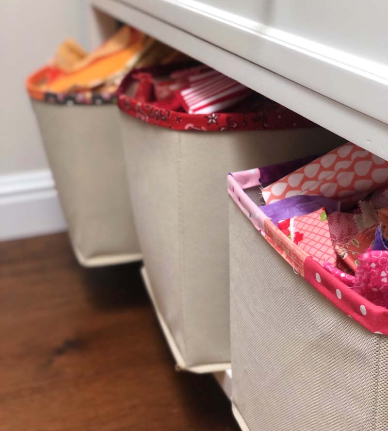 Colorful fabric scrap bins hold a library of past quilt projects.