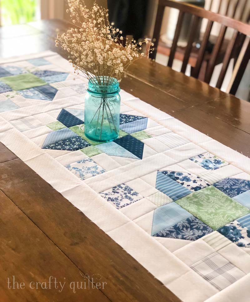 The Vinca Blossom quilt pattern can be used for a great table runner!  Made and designed by Julie Cefalu @ The Crafty Quilter.