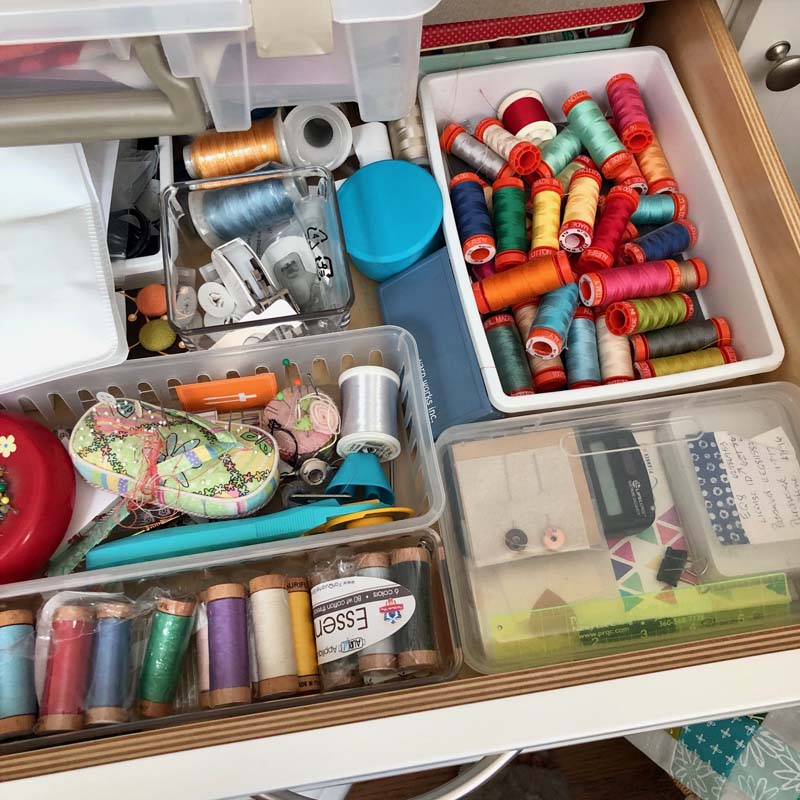 Thread stored in bins inside of a drawer.