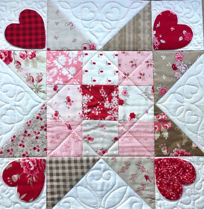 Quilting details of this Valentine's Day Table Runner by Julie @ The Crafty Quilter.  I used my Vintage Heart quilt block tutorial for this adorable table runner.