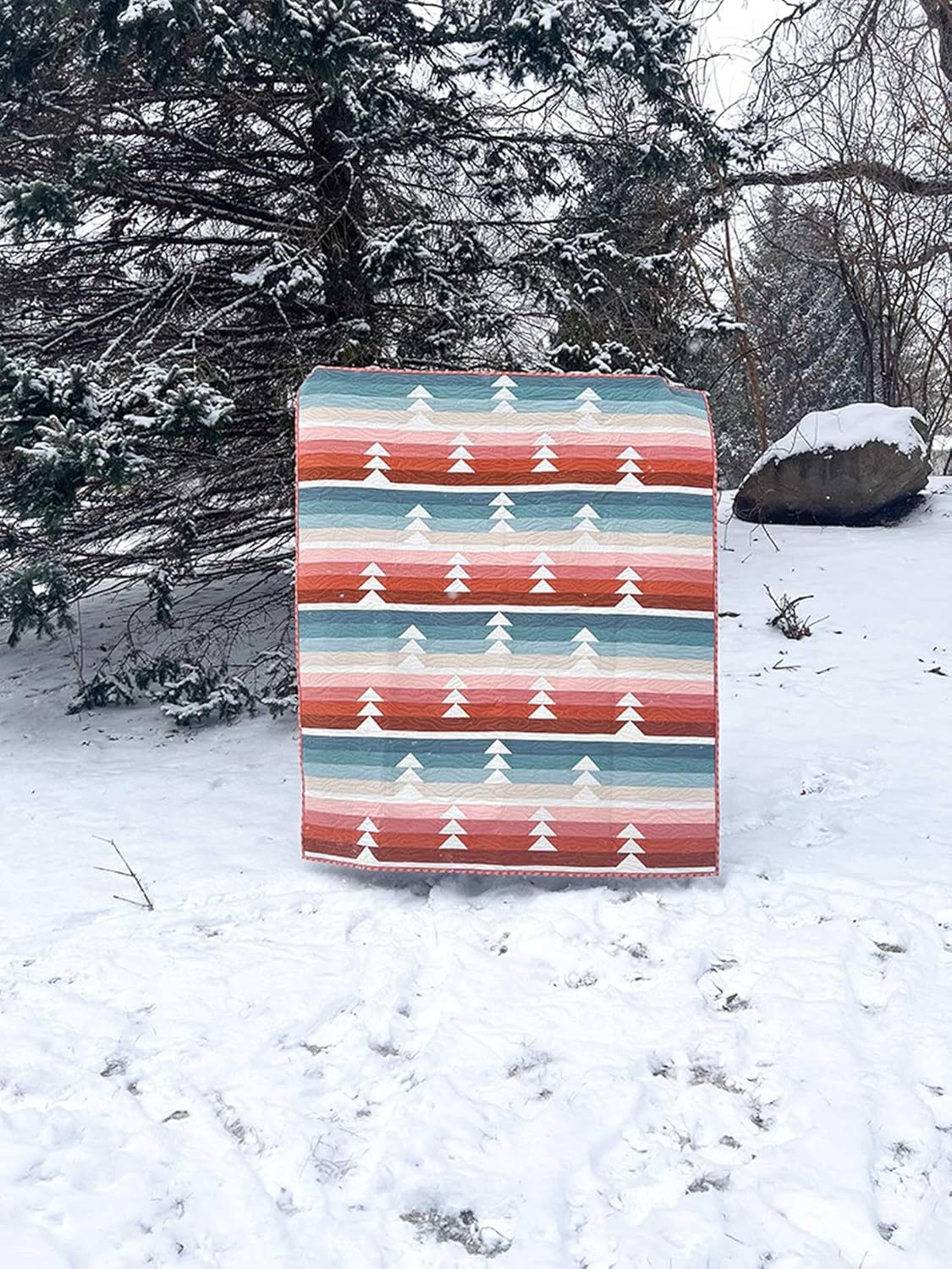 Photo of the Woodsy Quilt in a snow covered outdoor setting. By Abby Luchsinger, photo source C&T Publishing