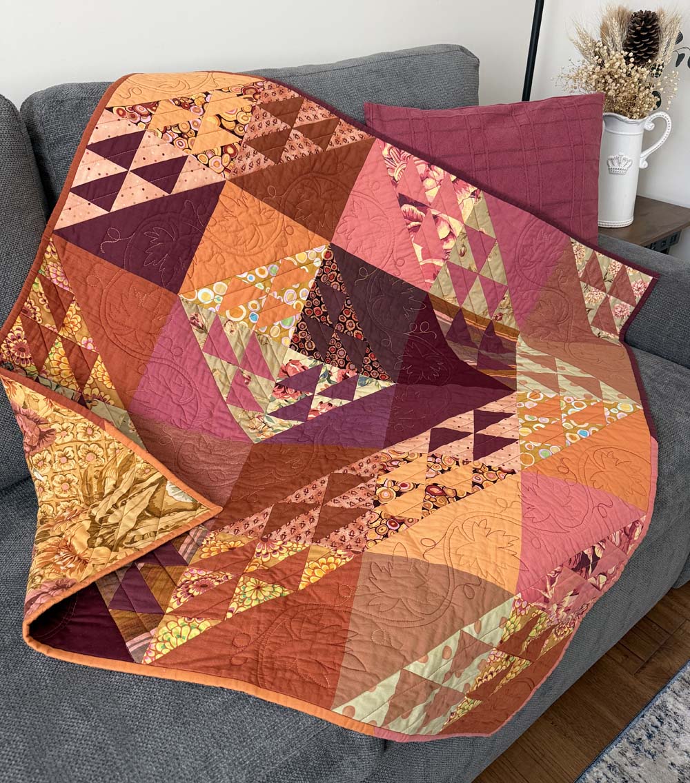 Season Reflections quilt draped on the couch.