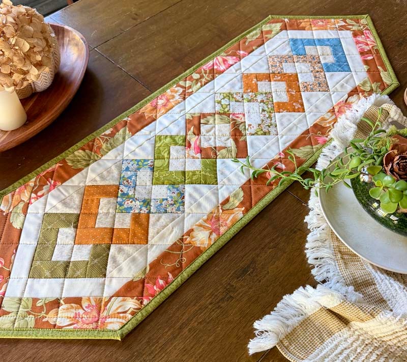 Fall table runner made with a charm pack from the Stripology Strip Quilt Pattern book.